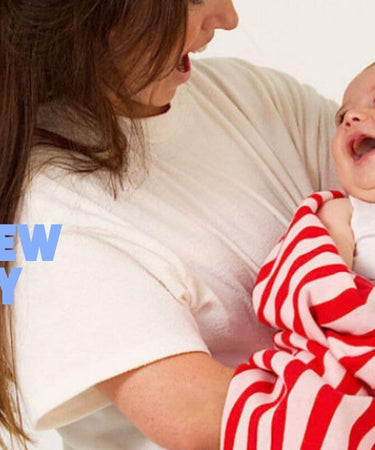 Woman holding a baby wrapped in a red and white striped blanket with promotional text overlay.